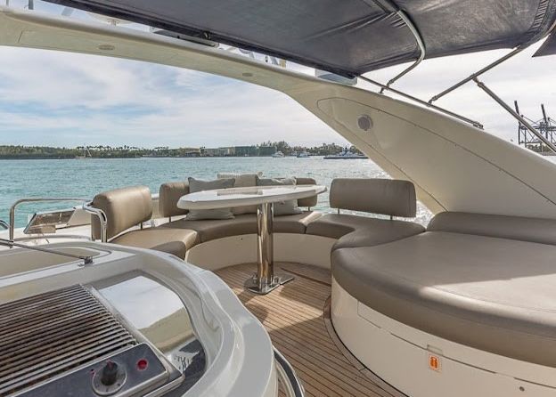 There is a table and chairs on the deck of a yacht.