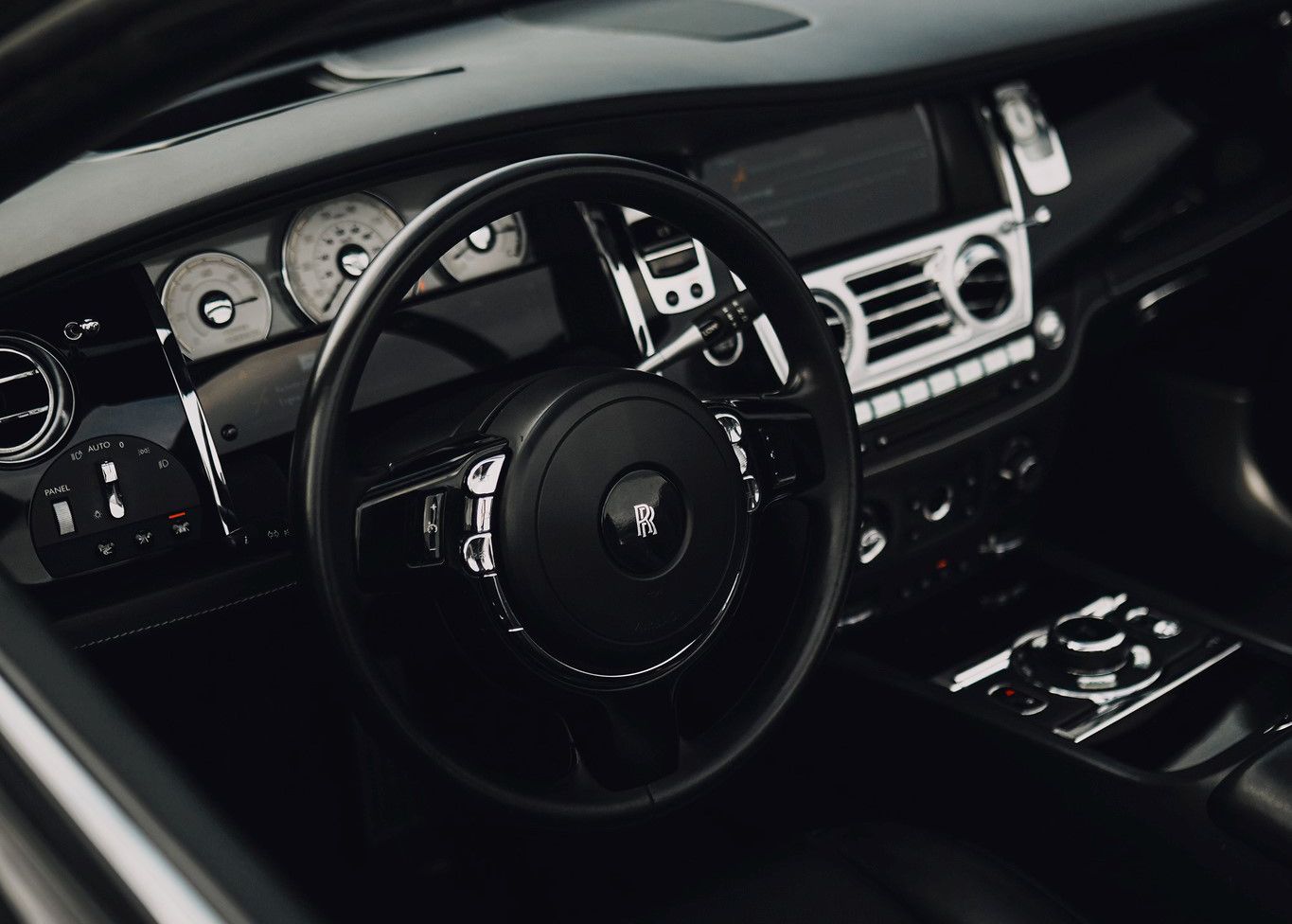 A close up of the steering wheel and dashboard of a car.