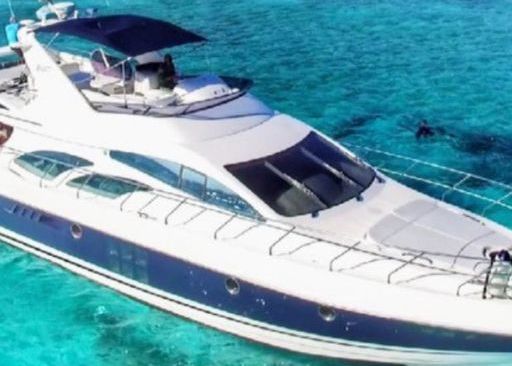 A white and blue yacht is floating on top of a body of water.