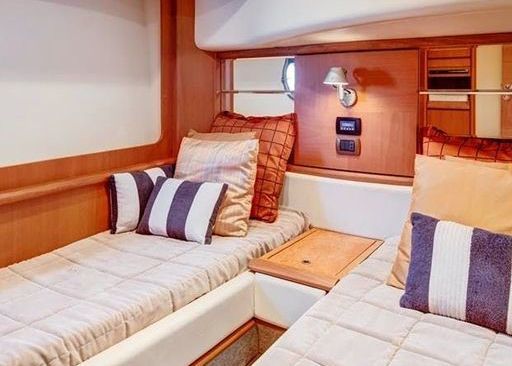 A bedroom on a boat with two beds and pillows.