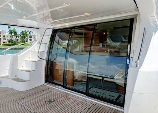 The back of a boat with sliding glass doors and stairs.