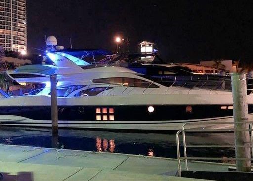 A large boat is docked at a marina at night.