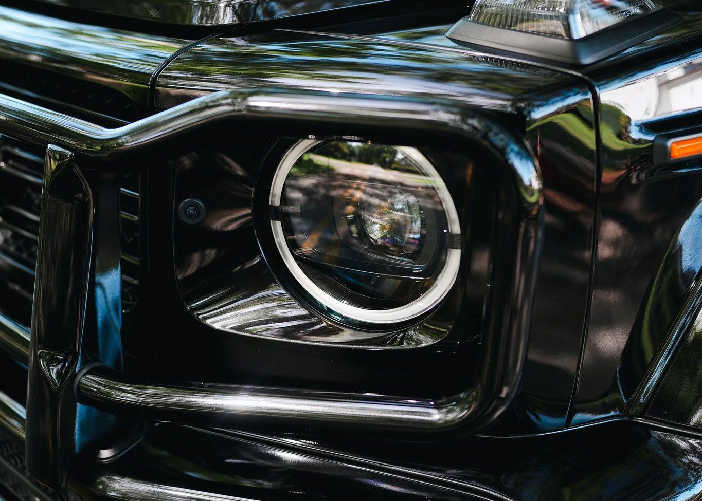A close up of a black car 's headlight.