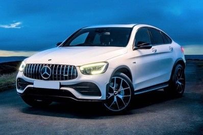 A white Mercedes Benz GLC coupe is parked on the side of a road.
