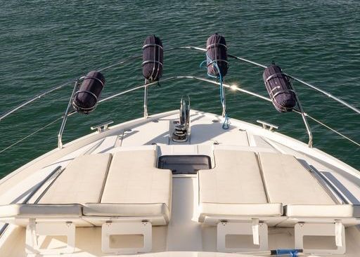 The front of a boat is floating on top of a body of water.