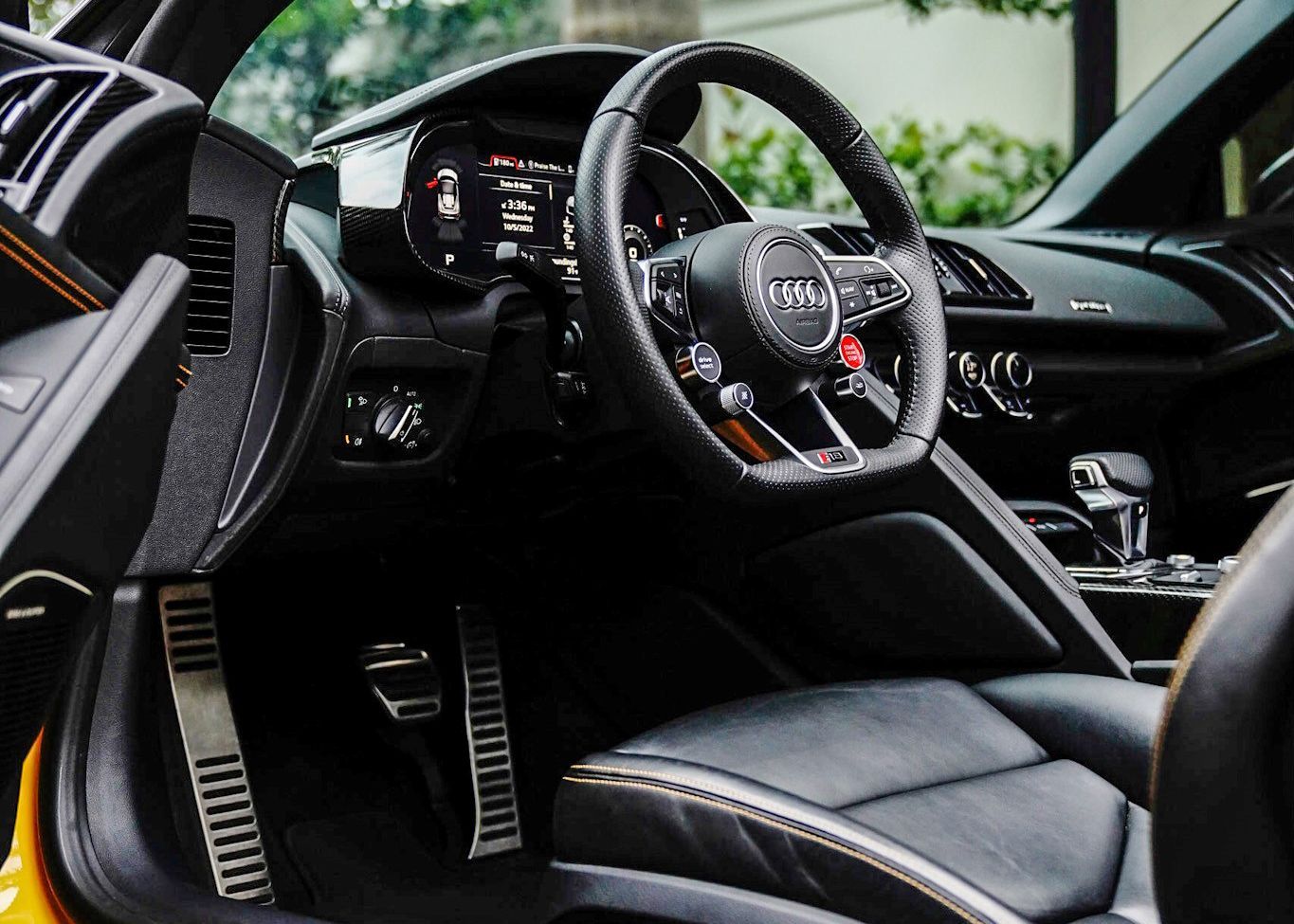 The interior of an Audi sports car with the door open.