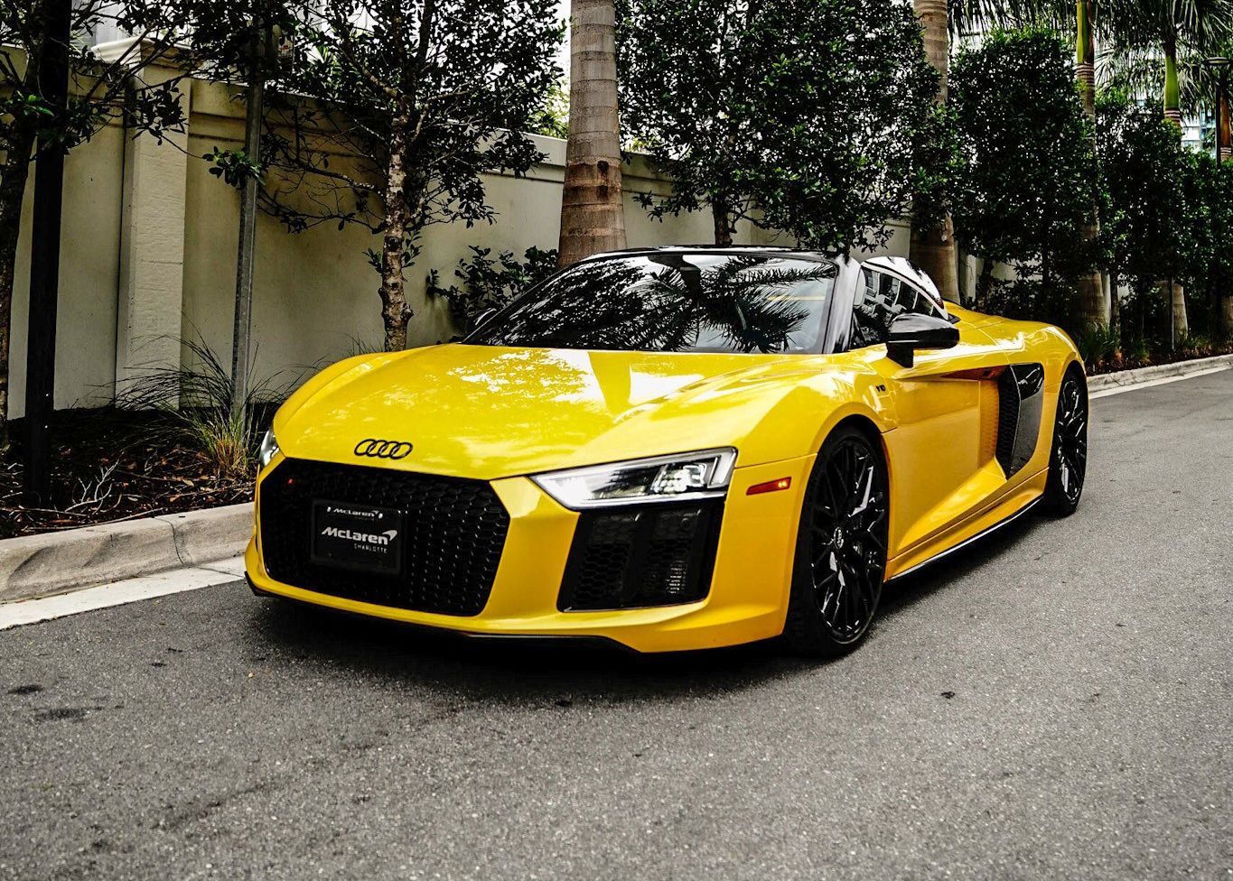 A yellow Audi R8 is parked on the side of the road.