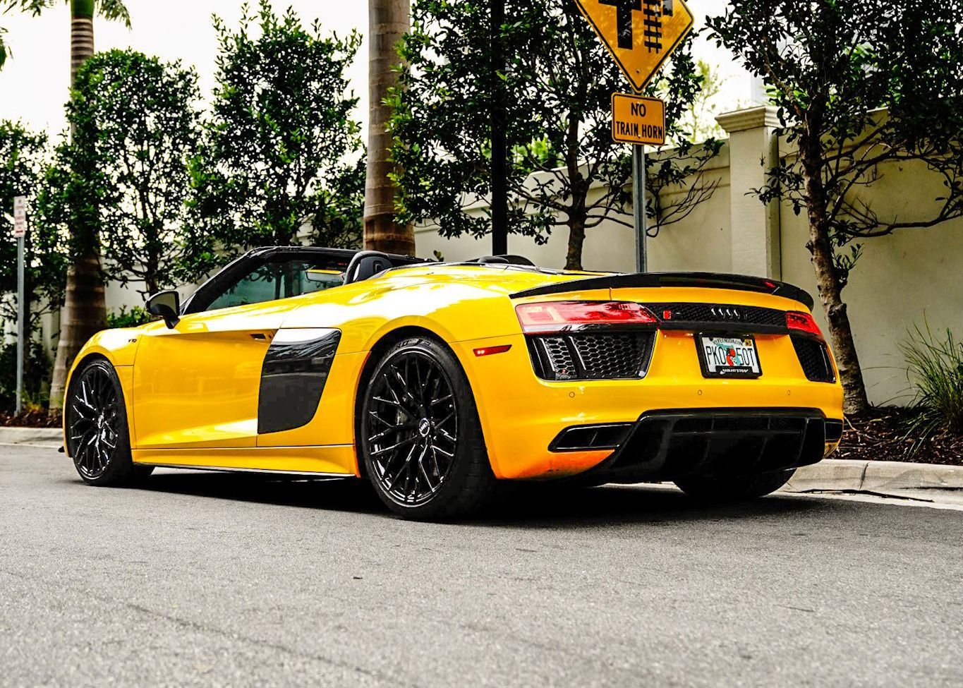 A yellow sports car is parked on the side of the road.
