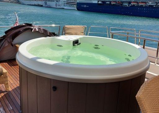 A round hot tub is sitting on the deck of a boat.