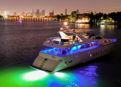 A yacht is floating on top of a body of water at night.