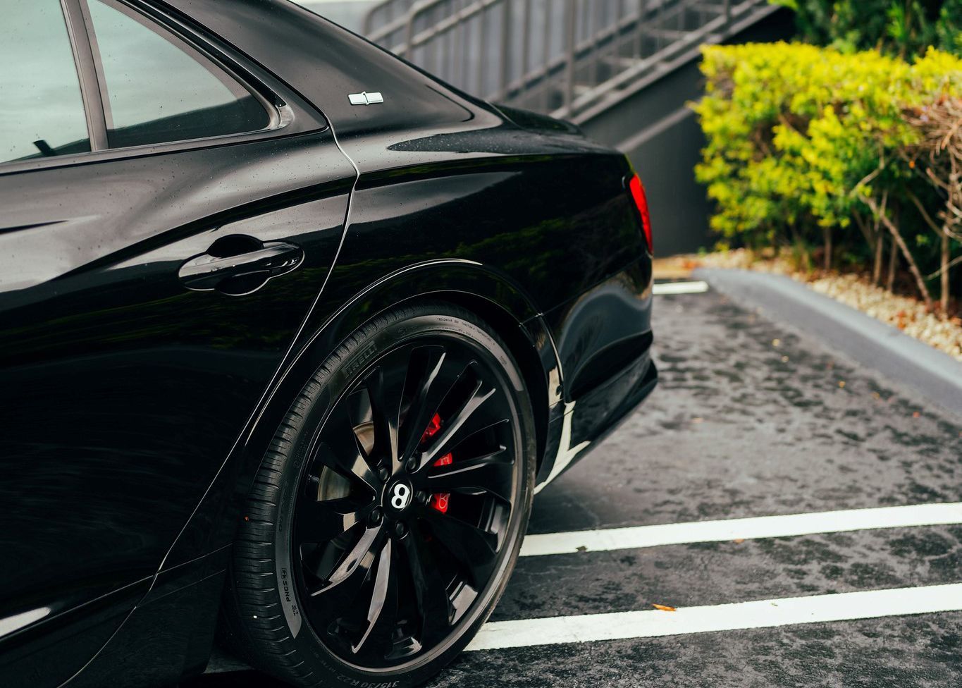 A black car is parked in a parking lot.