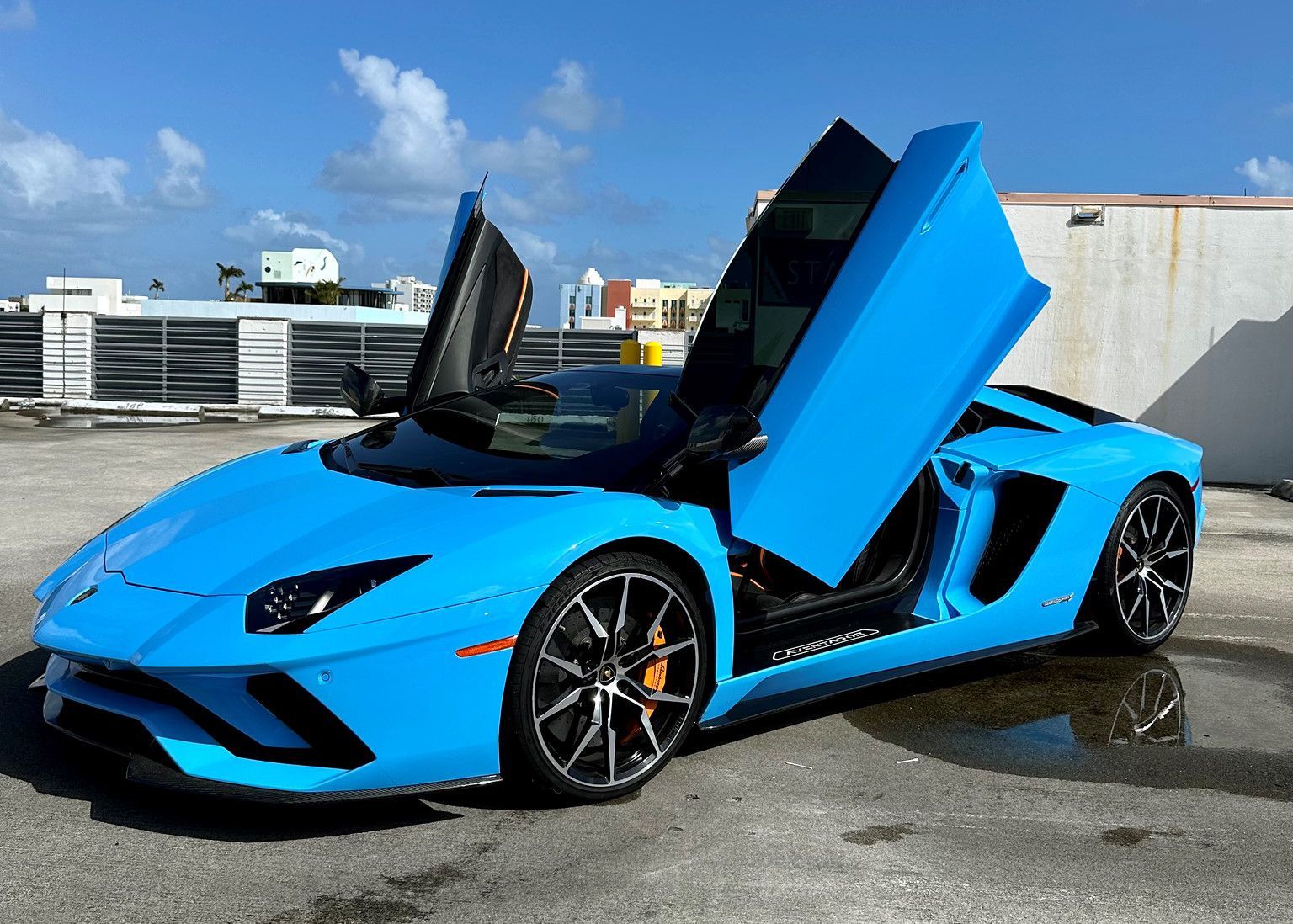 A blue Lamborghini Aventador with its doors open