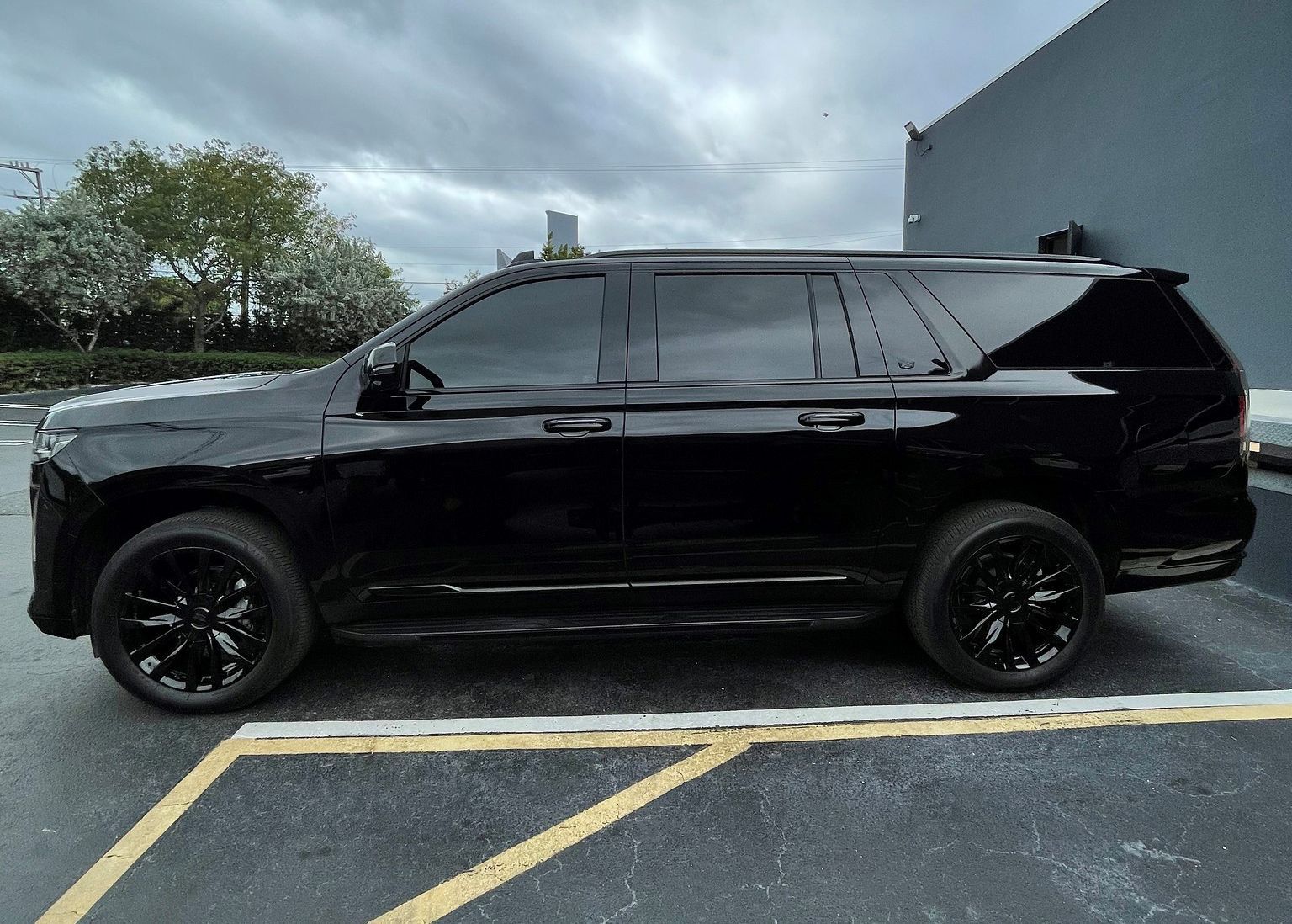 A black SUV is parked in a parking lot.