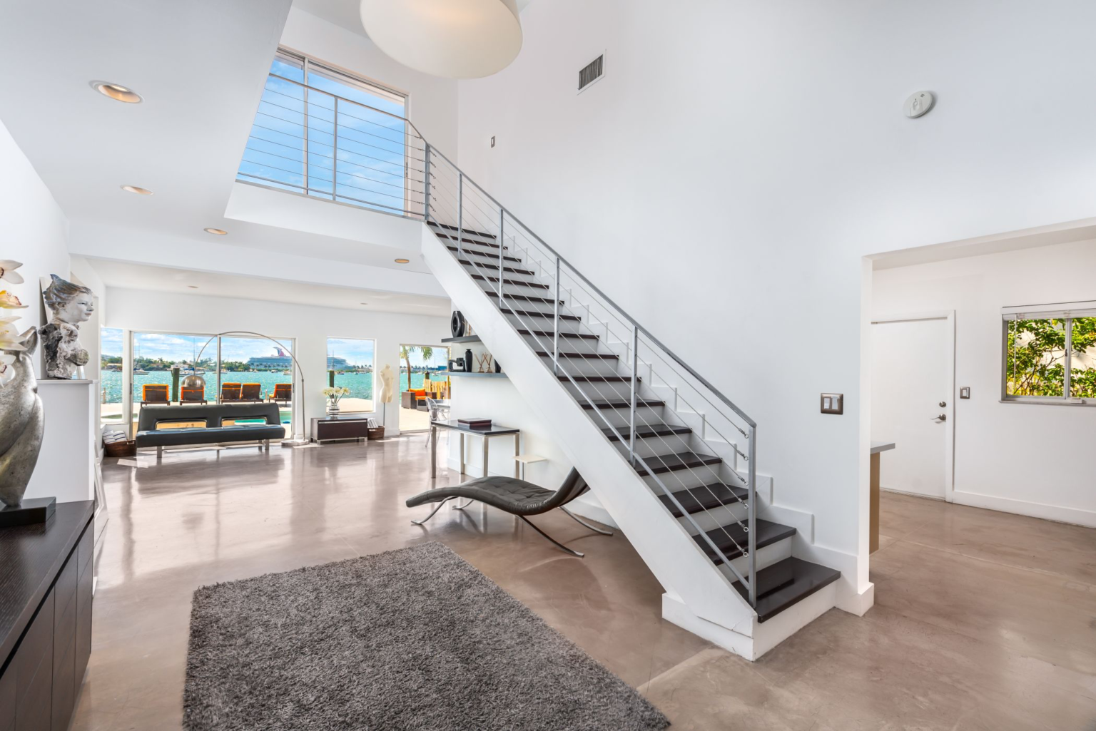 A living room with a staircase leading up to the second floor.