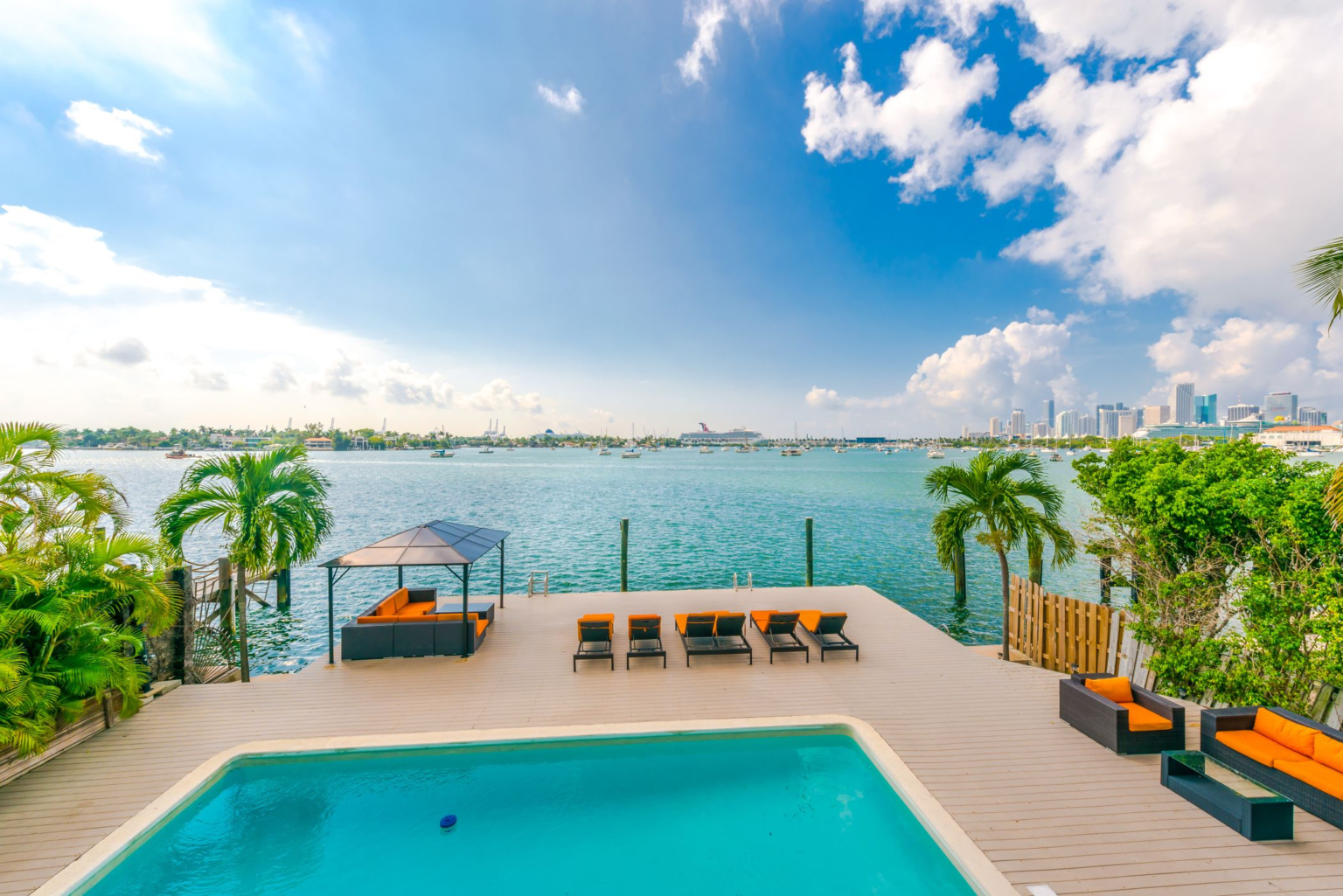 There is a large swimming pool with a view of the ocean.