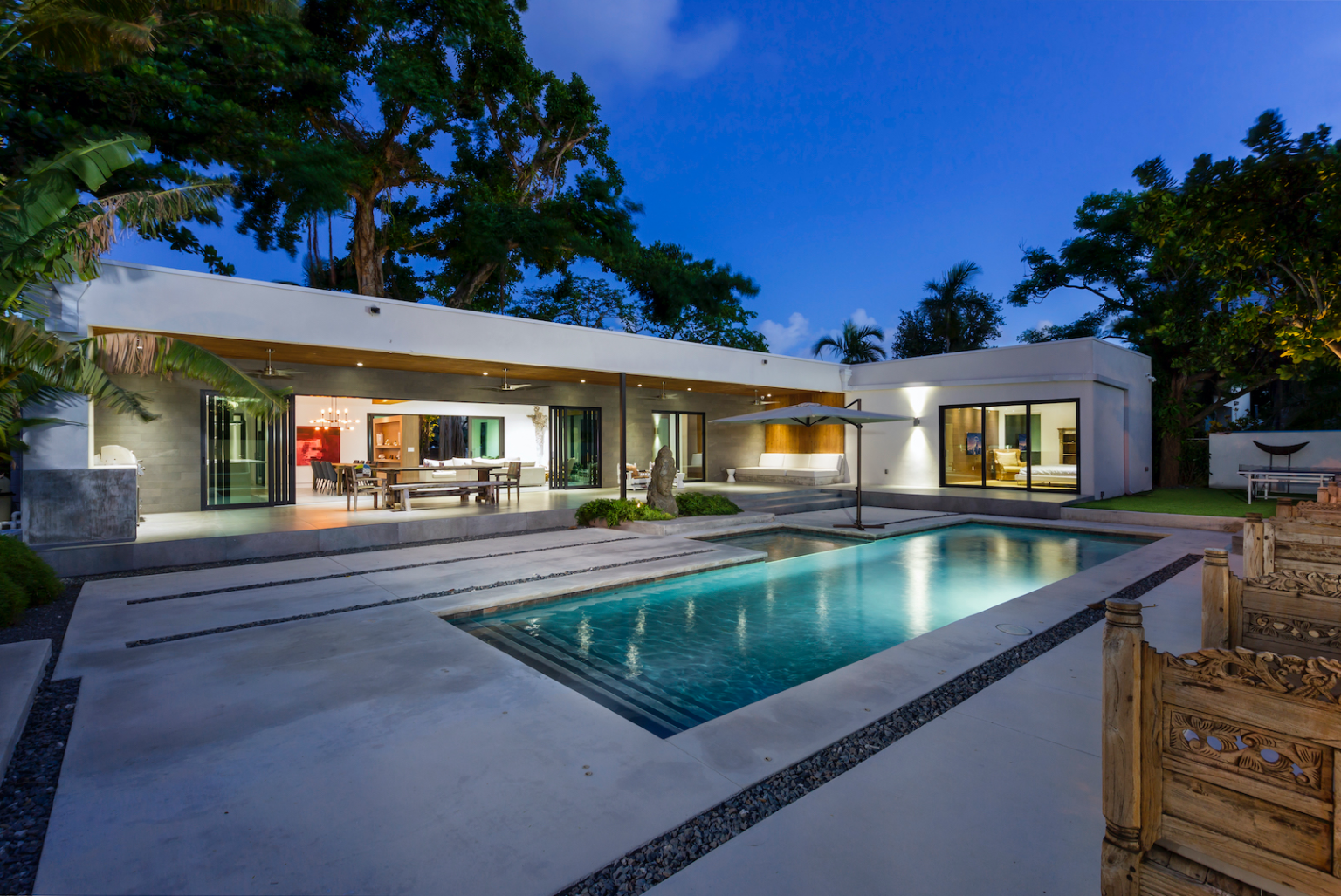 A house with a large swimming pool in front of it.