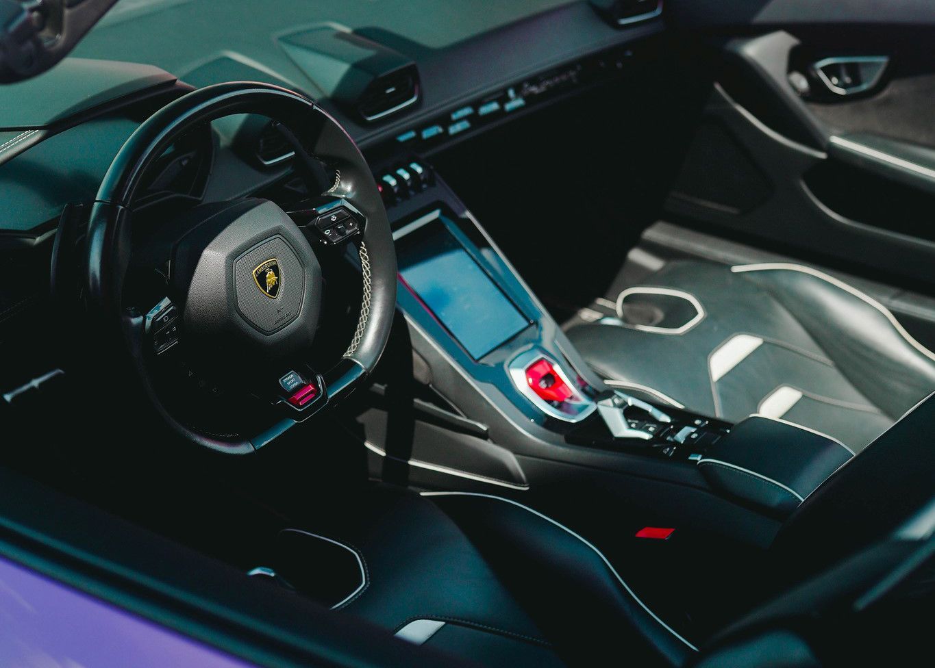 The interior of a purple sports car with a steering wheel.