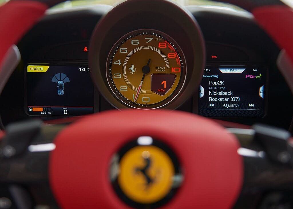 A close up of a Ferrari steering wheel and dashboard.