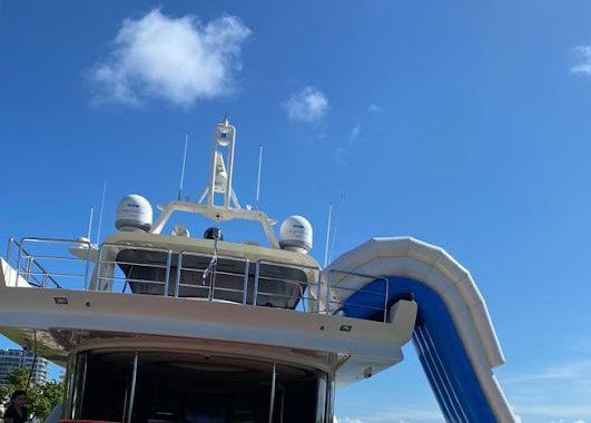 A large yacht with a slide attached to the back of it.