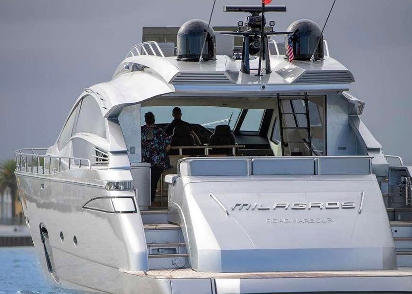 A large silver yacht is floating on top of a body of water.