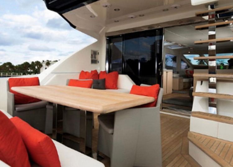 A table and chairs on the deck of a boat.