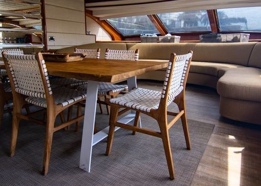 A wooden table and chairs in a living room on a boat.