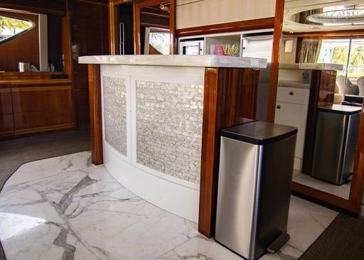 A stainless steel trash can is next to a counter in a kitchen.