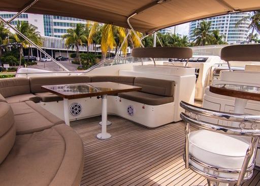 There is a table and chairs on the deck of a boat.