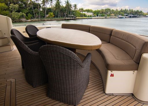 A boat with a table and chairs on the deck.