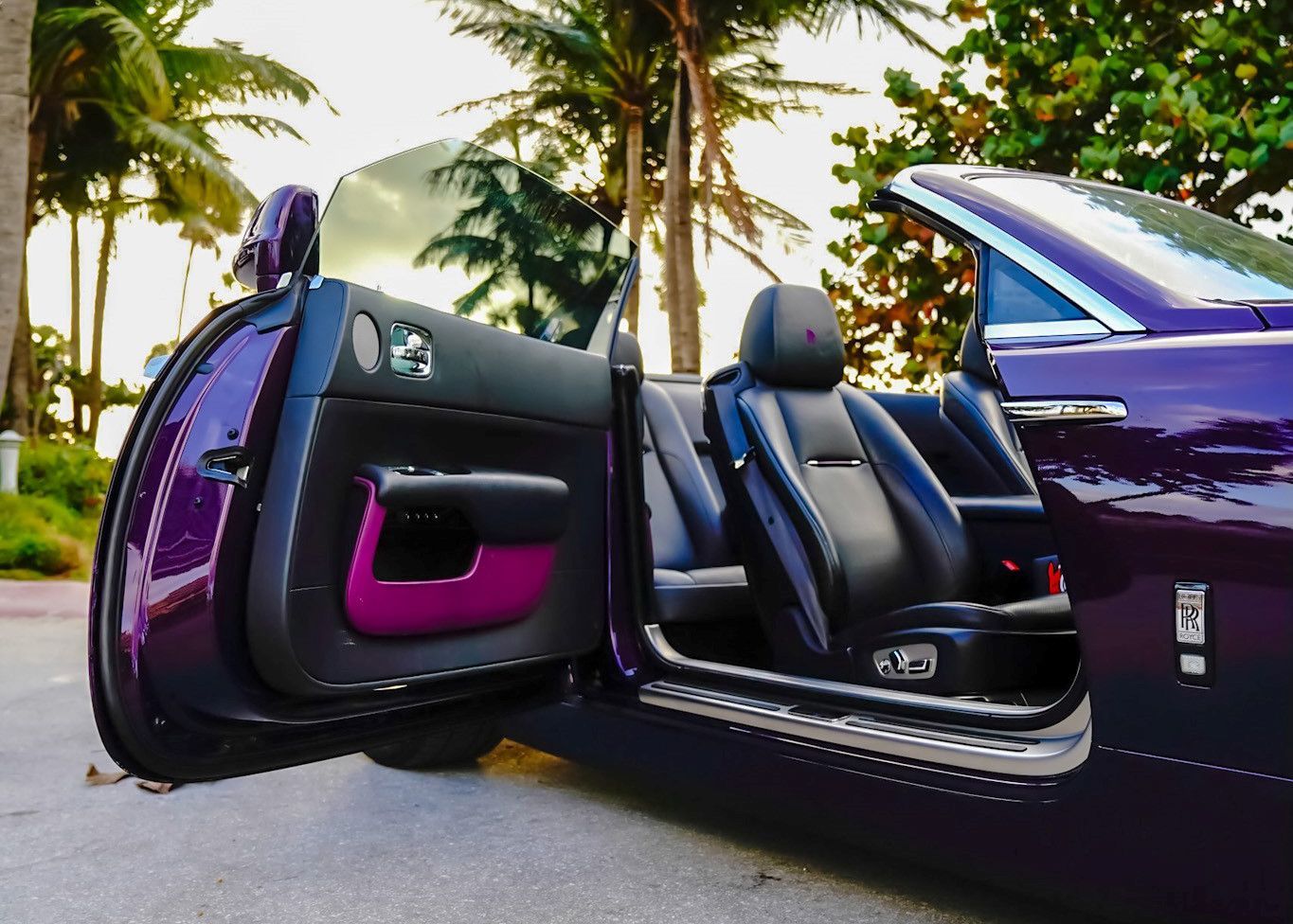A purple convertible car with the door open.