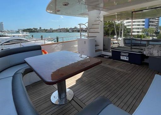 There is a table and chairs on the deck of a boat.