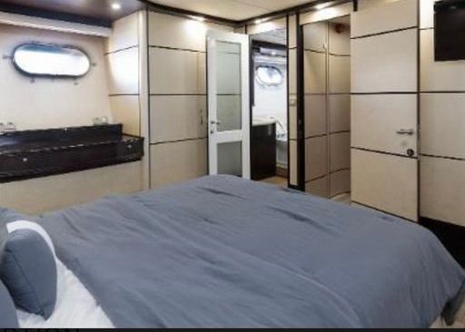 A bedroom on a boat with a large bed and a bathroom.