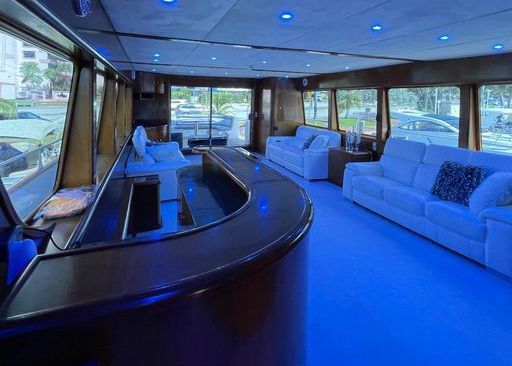 A living room on a boat with a bar and white couches.