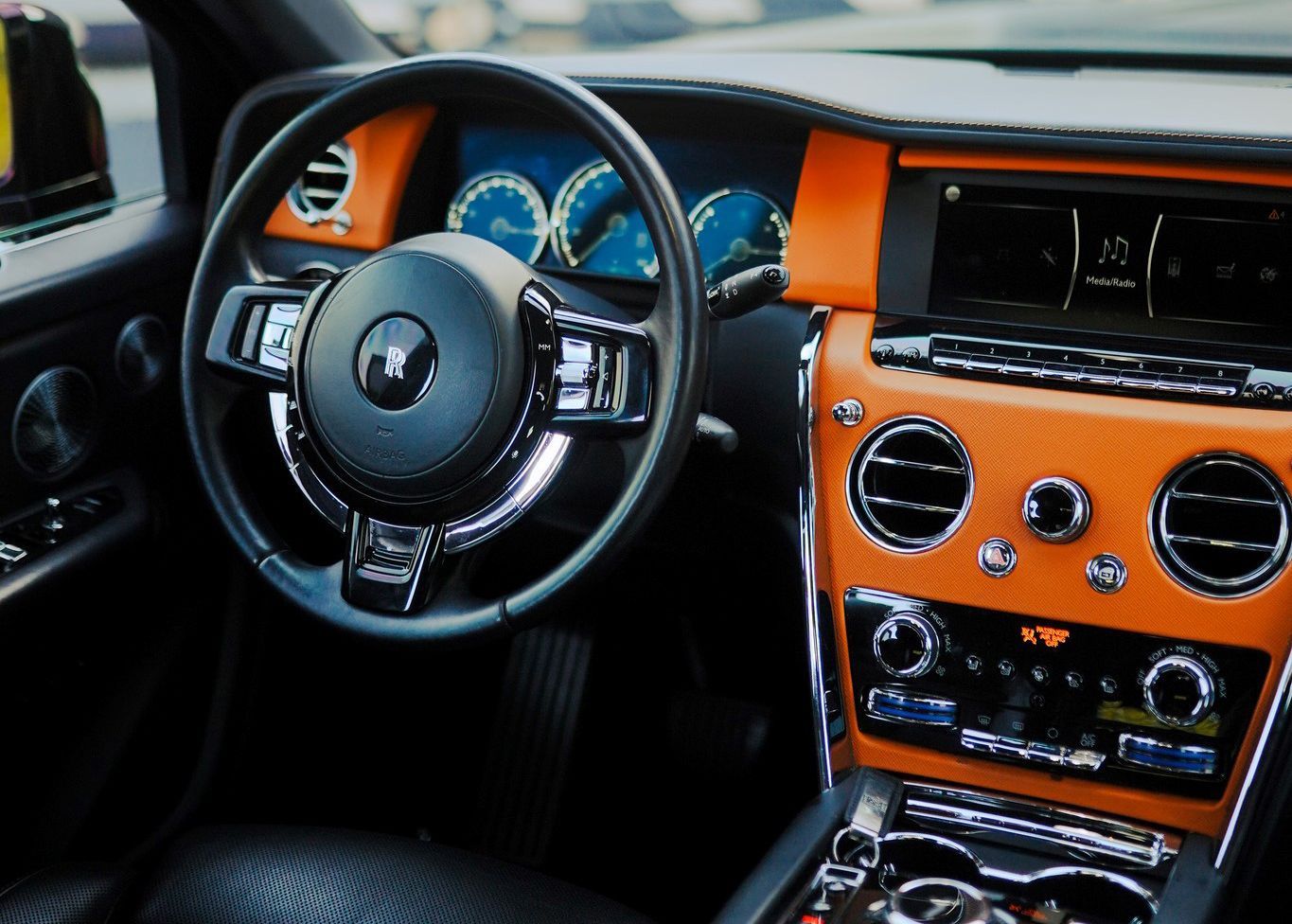 The interior of a luxury car with a steering wheel and dashboard.