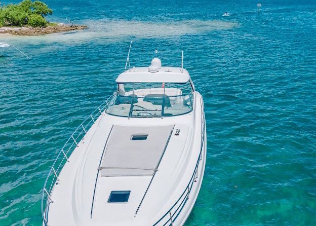 A white boat is floating on top of a body of water.