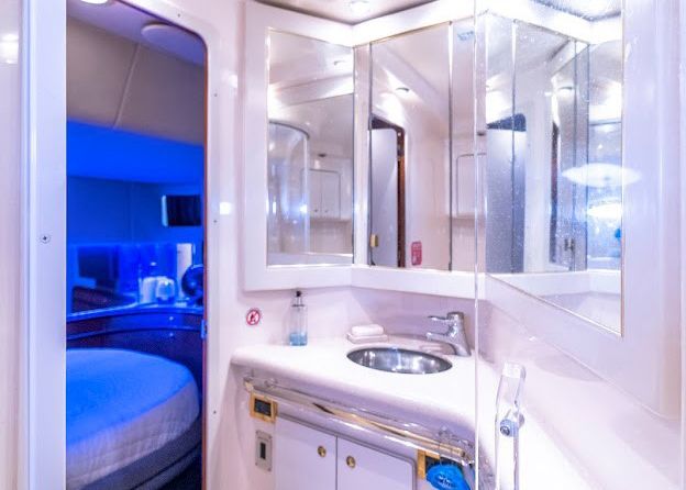 A bathroom on an airplane with a sink and mirrors.