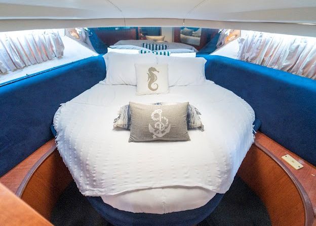 A bed on a boat with a seahorse pillow on it.