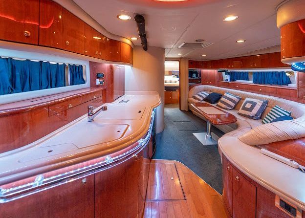 The inside of a boat with a couch and a sink.