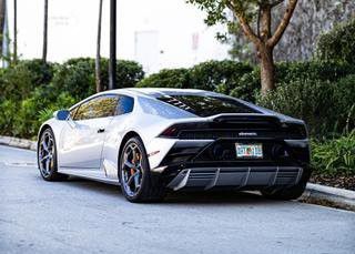 A white Lamborghini Huracan is parked on the side of the road.