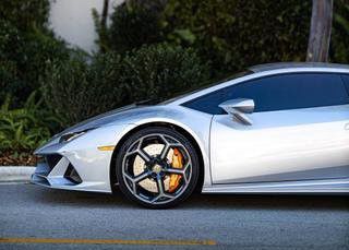 A silver Lamborghini Huracan is parked in a parking lot.