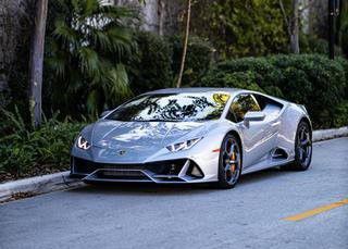 A silver Lamborghini Huracan is parked on the side of the road.