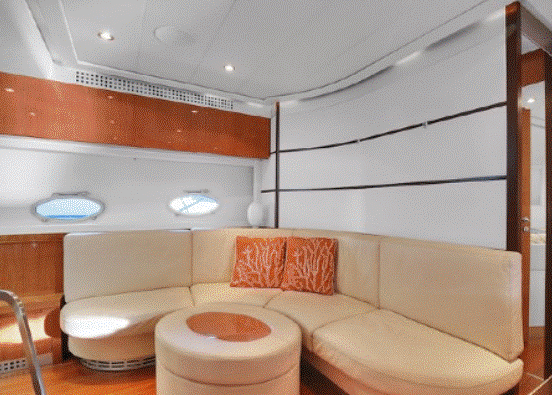 A living room on a boat with a couch and ottoman.