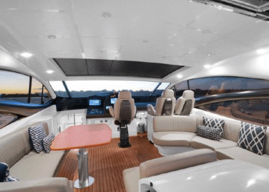 The inside of a boat with a table and chairs.