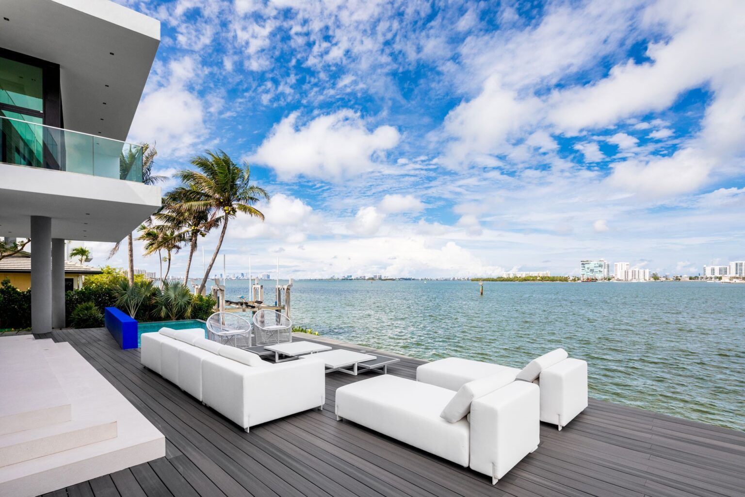 A modern house with a large deck overlooking the ocean.