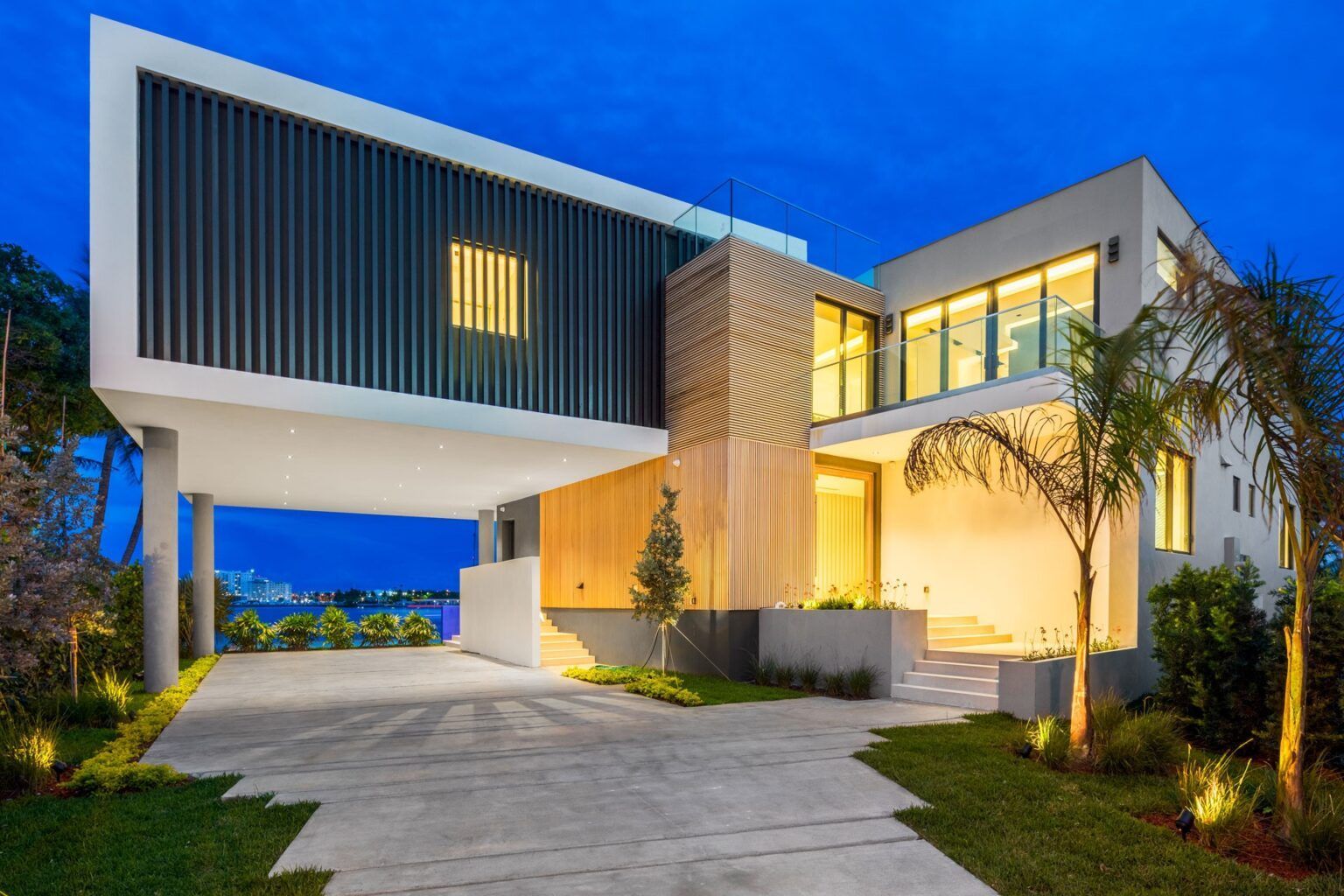 A large modern house with a lot of windows and a driveway.