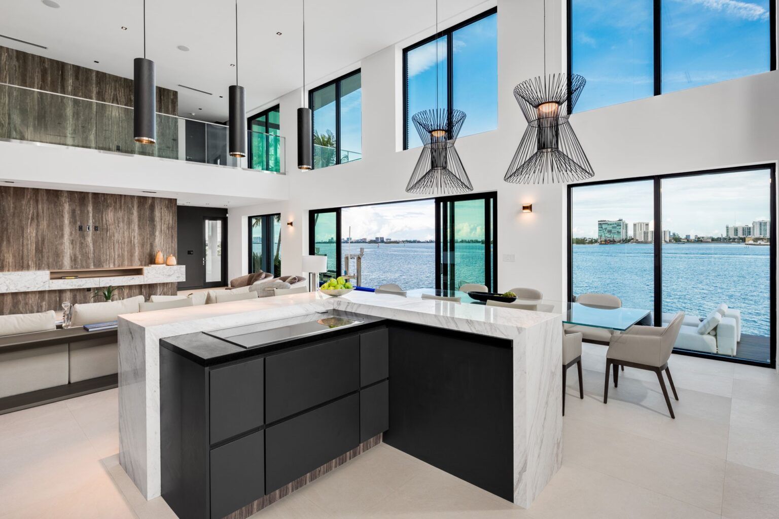 A kitchen with a large island and lots of windows overlooking the water.