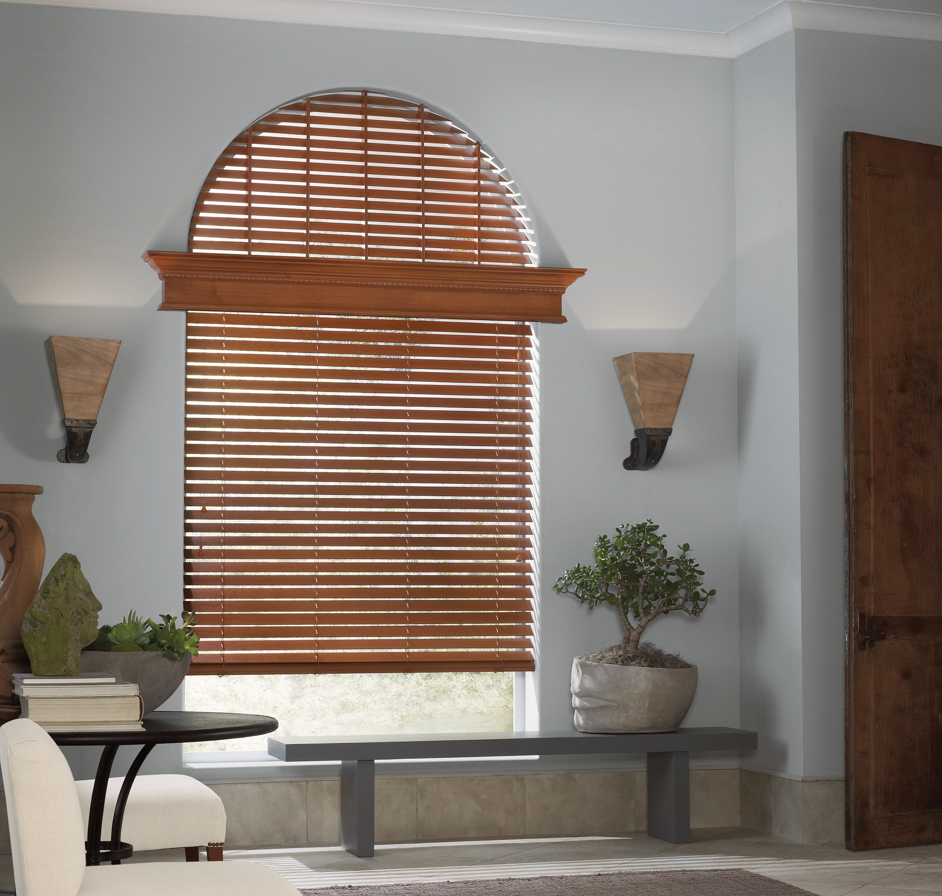 Hunter Douglas Parkland® Wood Blinds covering an arched window in a living room. 