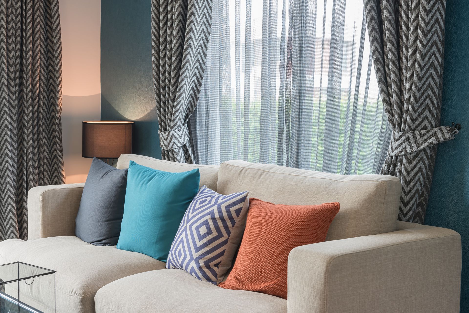 Patterned drapery in a living room with a sofa featuring colorful throw pillows. 
