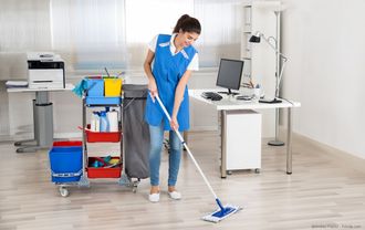 Eine Putzfrau reinigt ein Büro