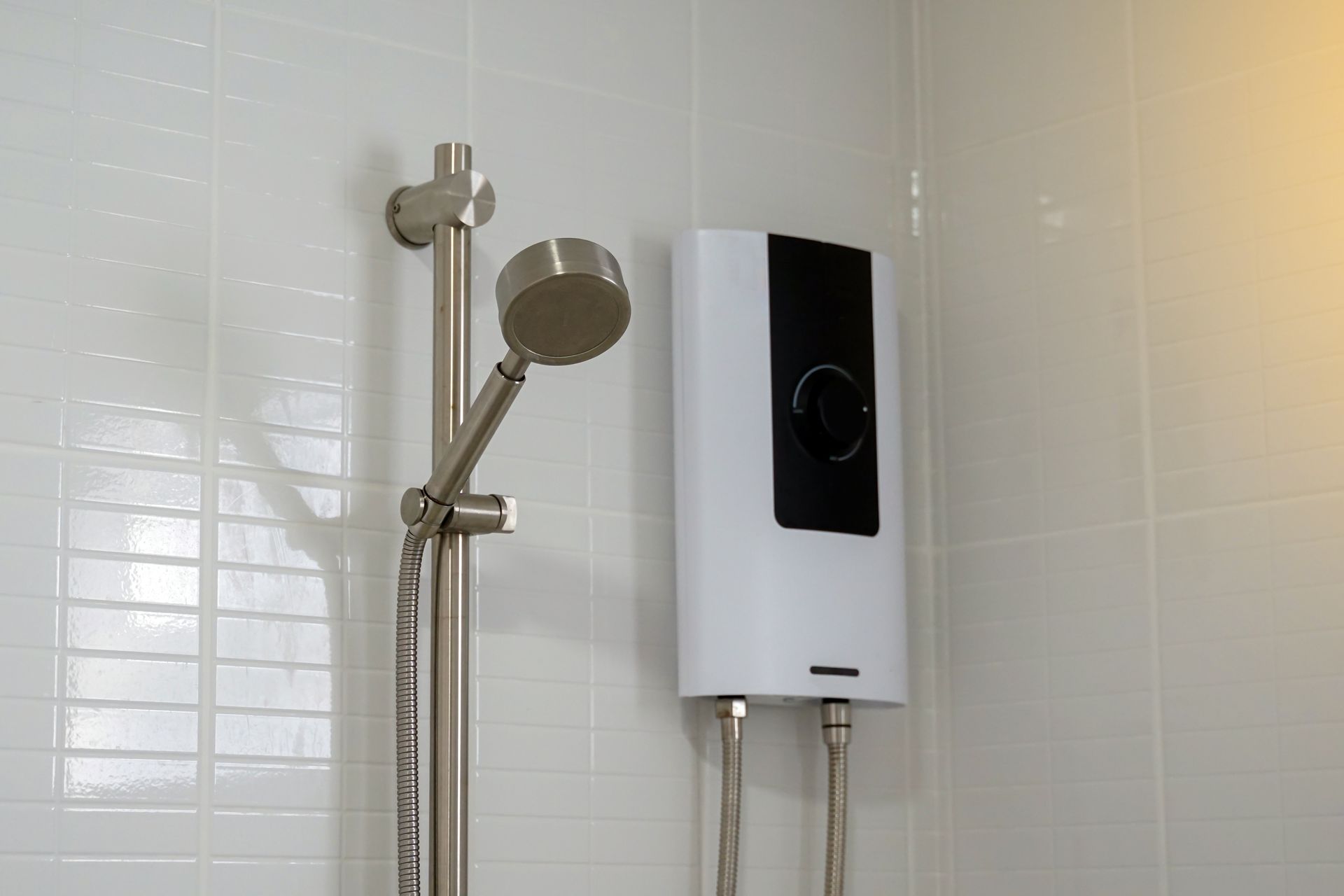 A bathroom with a shower head and a water heater.